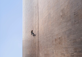 Window cleaner is working on the office building facade