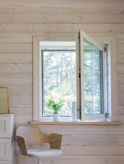White window with mosuito net in a rustic wooden house