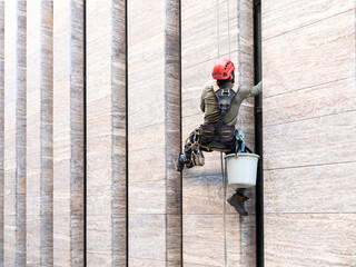Window cleaner is working on the office building facade