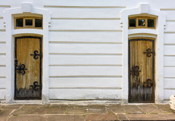 Two old doors in a white wall. Place for text about history.