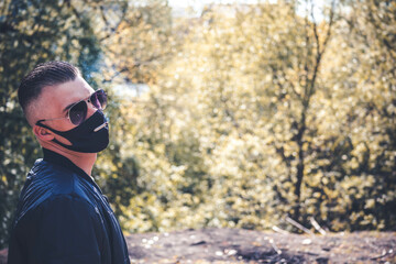 A guy in a black mask smokes a cigarette without taking off his mask