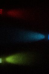 On a black rough background in small red and blue grain, parallel rays of red blue and yellow gradient light