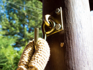 Detail of a hammock  hanging on a wooden post in a garden. Summer day.
