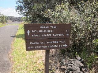 Hawaiʻi Volcanoes National Park trails sign. Wooden brown sign with white characters. April, 2019.