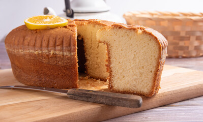Sliced ​​orange cake over wooden surface, selective focus.