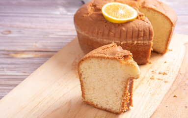 Sliced ​​orange cake over wooden surface, selective focus.