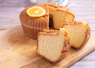 Sliced ​​orange cake over wooden surface, selective focus.