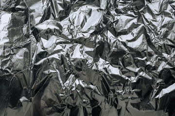 Abstract background, texture of shiny foil, colored crumpled paper for packing goods. Photo, top view.