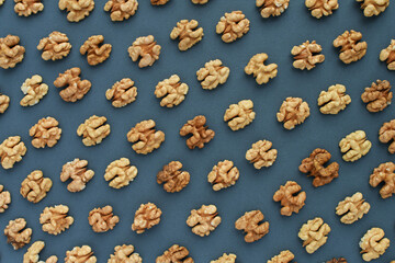 Seamless pattern of open walnuts on grey background.