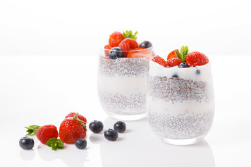 Chia seed pudding with berries on white background, raspberry, strawberry, blueberry.