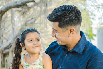 Fototapeta premium Dad and Daughter Smiling as They Look at Each Other, Mexican Family