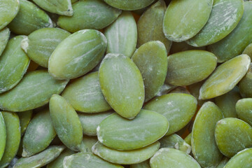 Top view: heap of uncooked green pumpkin seed - close up, macro. Healthy food concept