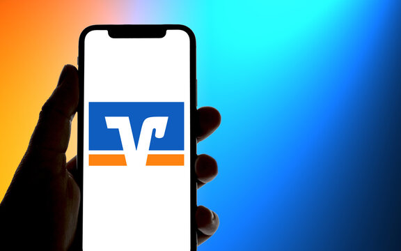 Smartphone mit Volksbank Logo, vor einem Farbverlauf des Volksbank Logos im Hintergrund mit Lichtwurf, Kreditinstitut, Online-Banking, Finanzen, Digitalisierung, 2022