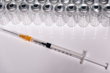 Vaccination cutlery in front of a series of neutral ampoules