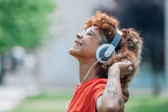 african american girl with headphones on the street listening to music