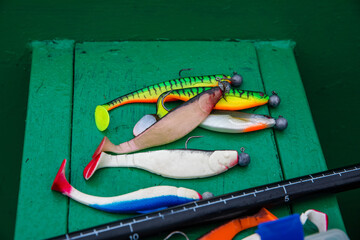 Several fishing soft lures for catching pike on the bench of a fishing boat