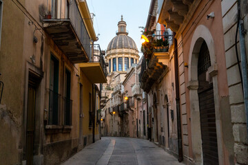 Fototapeta na wymiar Mediterranean city on the island of Sicily, with a church dome at the end of the street