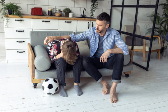 Teenager Boy With A Backpack Disappointed And Sad Because Of Football Game. Dad Supporting Him. Back To School Concept. Cute Brown Pet Dog Around