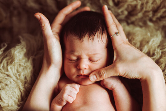 Crop parent stroking adorable sleeping baby