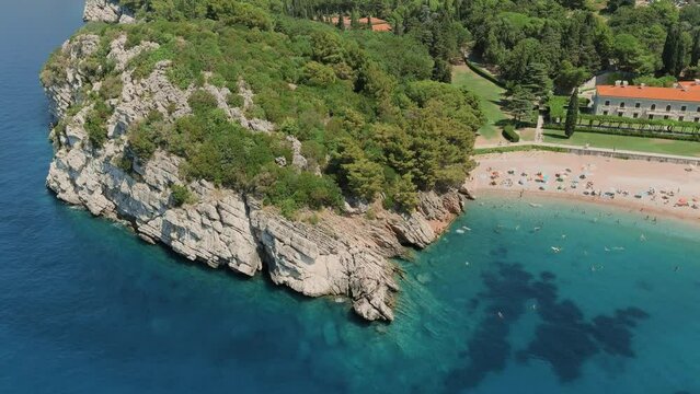 Montenegro. Adriatic Sea. Milocer beach. Summer. Sunny weather. High season. A very popular tourist spot. Drone. Flight. The camera moves backward