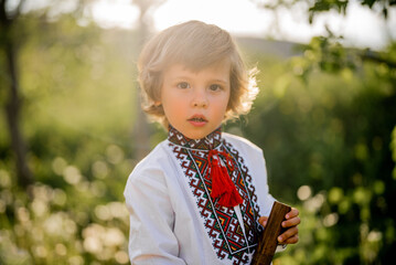 Portrait of little boy with woodwind wooden flute - ukrainian sopilka. Folk music concept. Musical...