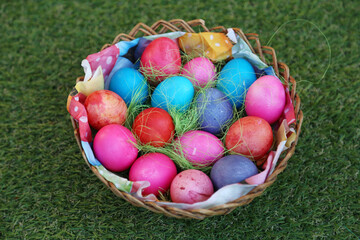 Various colored eggs in a wicker basket. Bright resurrection of Christ the most ancient Christian holiday