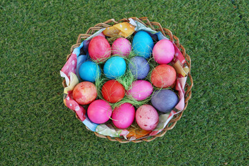 Various colored eggs in a wicker basket. Bright resurrection of Christ the most ancient Christian holiday