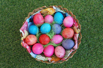 Various colored eggs in a wicker basket. Bright resurrection of Christ the most ancient Christian holiday
