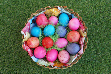 Various colored eggs in a wicker basket. Bright resurrection of Christ the most ancient Christian holiday
