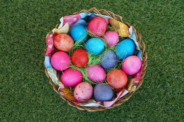 Various colored eggs in a wicker basket. Bright resurrection of Christ the most ancient Christian holiday