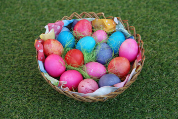 Various colored eggs in a wicker basket. Bright resurrection of Christ the most ancient Christian holiday
