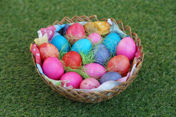Various colored eggs in a wicker basket. Bright resurrection of Christ the most ancient Christian holiday