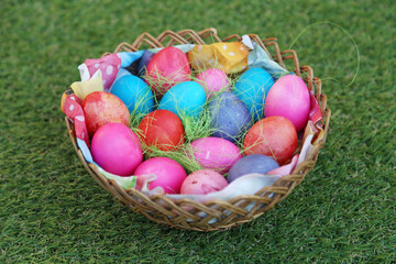 Various colored eggs in a wicker basket. Bright resurrection of Christ the most ancient Christian holiday