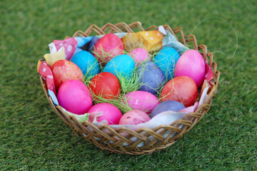 Various colored eggs in a wicker basket. Bright resurrection of Christ the most ancient Christian holiday