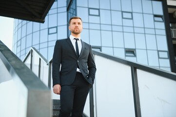 Modern businessman. Confident young man in full suit and looking away while standing outdoors with cityscape in the background