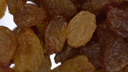 Raisins fall on glass on a bright white background. Raisins macro bottom view.