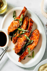 fried pieces of salmon marinated in sweet and sour sauce in a plate with soy sauce. asian food