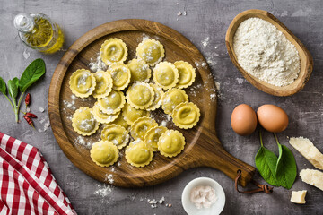 fresh raw italian ravioli on the table with cooking ingredients. home cooking