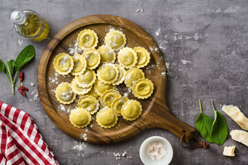 fresh raw italian ravioli on the table with cooking ingredients. home cooking