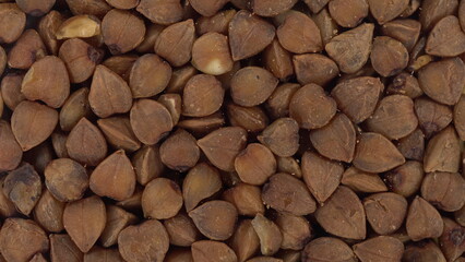 Buckwheat falls on the glass on a bright white background. Macro bottom view of buckwheat.
