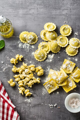 different types of fresh raw italian ravioli on the table with cooking ingredients. home kitchen