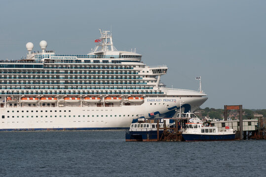 Southampton, England, UK. Cruise ship departing Port of Southampton passing Hythe Pier and small ferry boats on berth.