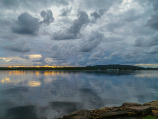 Autumn sunrise and rain clouds over the bay