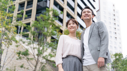 タワマンの前に立つカップルのポートレート