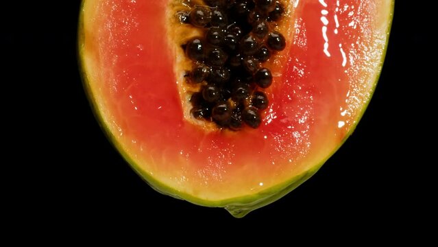 Sweet papaya half isolated on black background chroma key, fresh sliced pawpaw close-up. Tropical fruits. Healthy eating, vegan food.