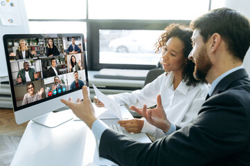 Business colleagues, co-founders of the company, sit at a table in the modern office in front of a...