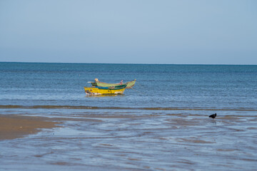 Ocean at low tide showing corals, rocks and small fishing boats in Bahia, Brazil, South America, Atlantic Ocean
