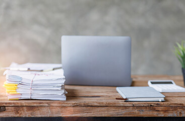 document Piles of paperwork in the office and laptop on the desktop