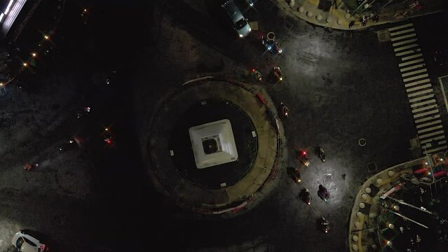 Top down view aerial footage of night busy traffic around monument intersection