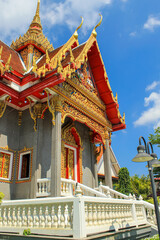 Stairs and entrance of the Thai buddhist temple in Phuket, Thailand. Blue sky, copy space for text, wallpaper, golden, red, background